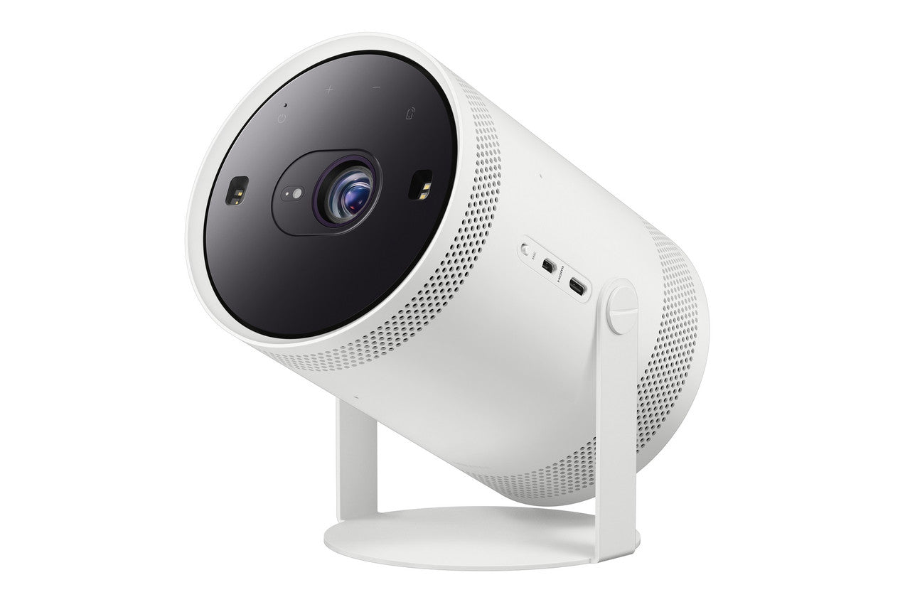 A white cylindrical smart projector device with a black front lens area, standing on a white base against a plain white background.